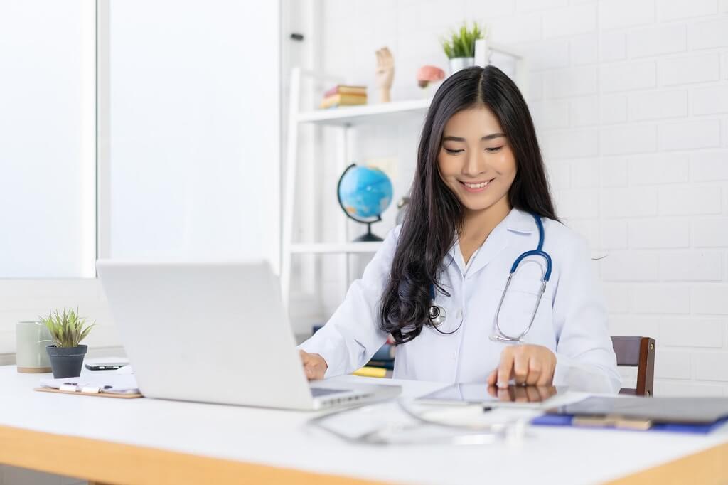 Woman doctor working on ECFMG updates for 2024